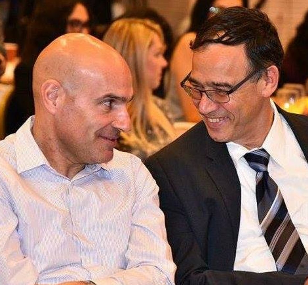 שי ניצן עם אפי נוה בתמונה מחייך ומאחורי הגב תוקע סכינים
